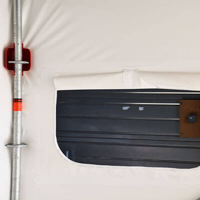 Fenêtre pour film thermo-rétractable et protection rouge sur une rosace d'échafaudage