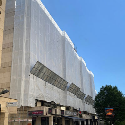 Bâche blanche pour échafaudage posée sur la façade d'un immeuble