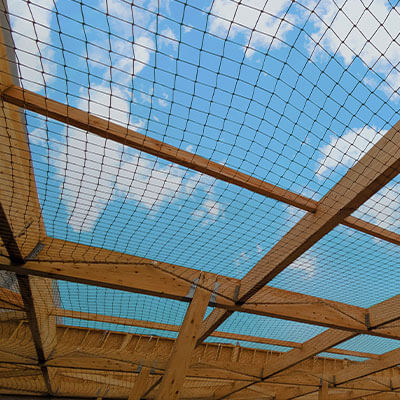 Filet anti-pigeons posé sur la charpente d'une toiture en cours de construction