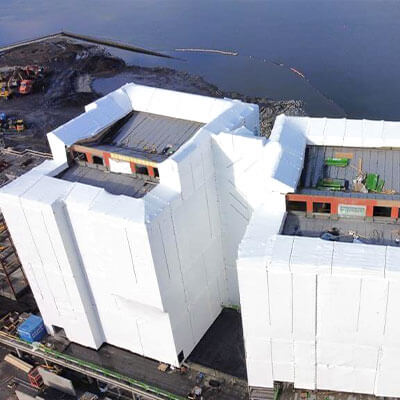 Bâtiments entiers recouverts de film thermo-rétractable sur échafaudage